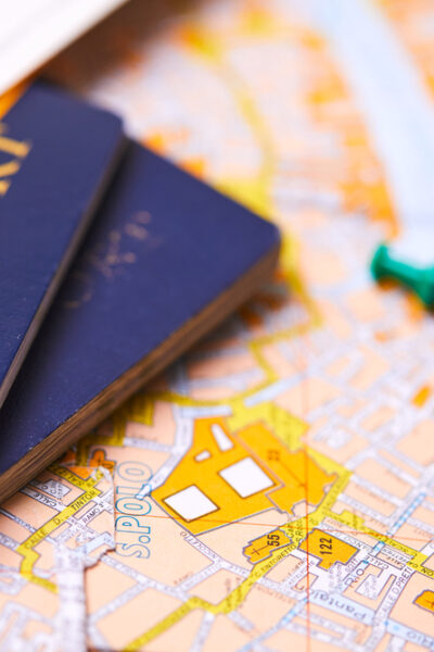 pins marking travel itinerary points on map and passport