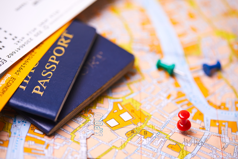 pins marking travel itinerary points on map and passport